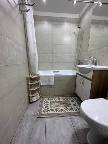 a bathroom with a tub and a sink and a toilet at Star Rent Hotel in Chişinău