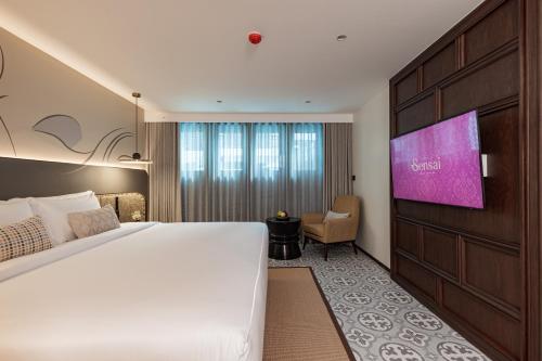 a hotel room with a large bed and a flat screen tv at Hotel Sensai Nimman Chiang Mai - Adults Only in Chiang Mai