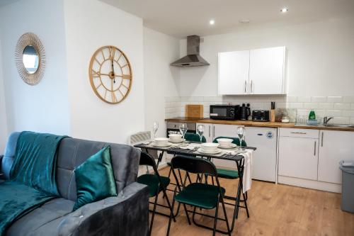 a living room with a couch and a table with chairs at Bv Charming 2-Bedroom Apartment by Kirkstall Shopping Centre, Free Parking in Leeds