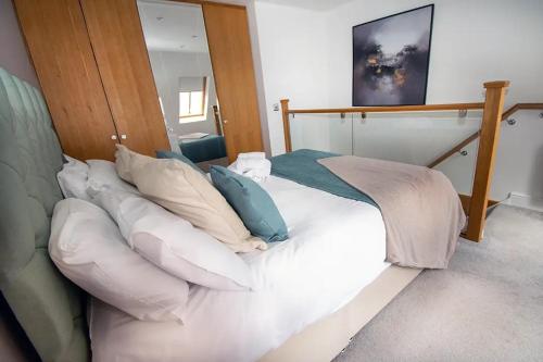 a bed with pillows on it in a room at Seafront Cottage - The Nook in Cardiff