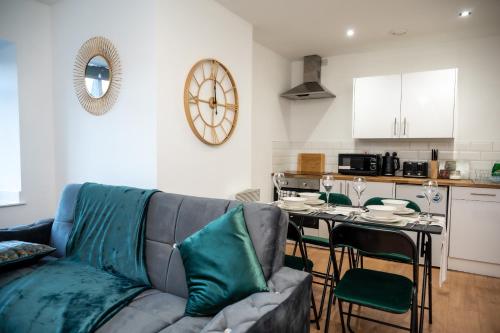 a living room with a couch and a table with chairs at Hayy Apartments Comfort in the Heart of Kirkstall in Leeds