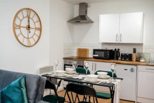 a kitchen with a table with wine glasses on it at Hayy Apartments Comfort in the Heart of Kirkstall in Leeds