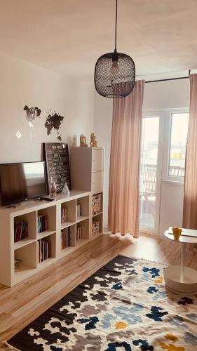 a living room with a television and a book shelf at Urban Sunset Loft in Bucharest