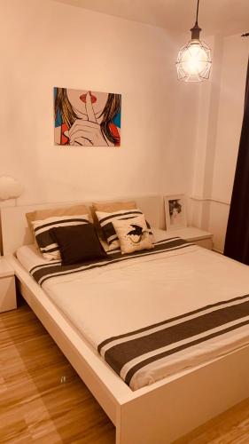 a large bed in a bedroom with a painting on the wall at Urban Sunset Loft in Bucharest