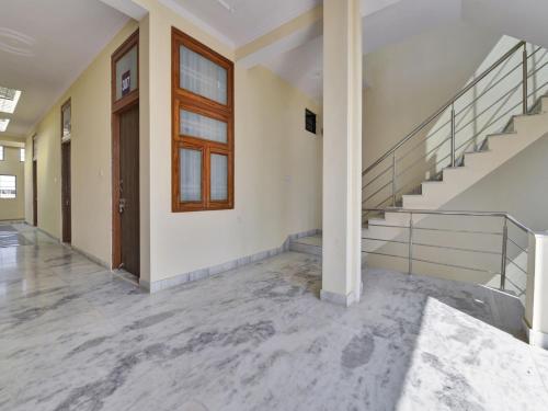 um quarto vazio com escadas e uma porta em OYO Flagship Hotel Hastinapur Residency em Jaipur