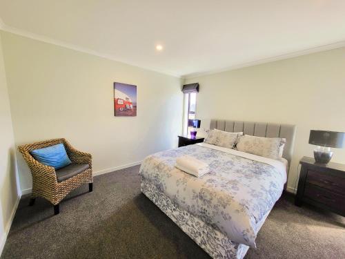 a bedroom with a bed and a chair in it at White Stone Apartment in Lake Tekapo