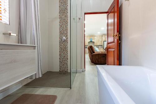 a bathroom with a tub and a glass door at RSA Lodge in Benoni