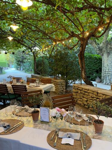 a table set up for a wedding under a tree at Le Mas des Grès & Sous les Platanes in Lagnes