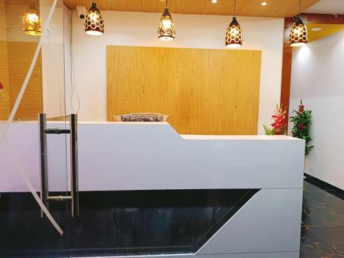 a white counter in a room with pendant lights at Hotel Maan Palace in Vadodara