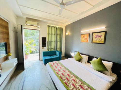 1 dormitorio con 1 cama grande y 1 silla azul en Hotel Dayal Regency near IMT Chowk Manesar, Manesar en Gurgaon