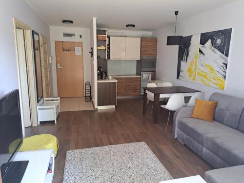 a living room with a couch and a table at Apartament w Bursztynowych Komnatach in Darłówko