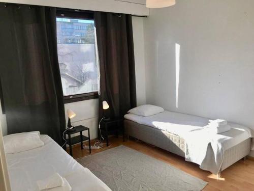 sypialnia z 2 łóżkami i oknem w obiekcie Kotimaailma - Kolmio Koskelassa, Käpylän lähellä Helsingissä w Helsinkach