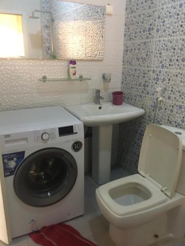 a bathroom with a washing machine and a sink at Résidence Éden mamelles in Dakar