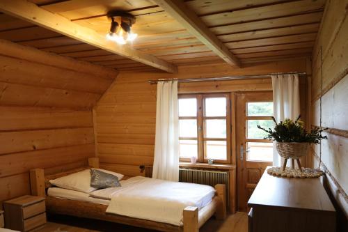 a bedroom with a bed in a wooden room at Na Bugaju in Czarny Dunajec