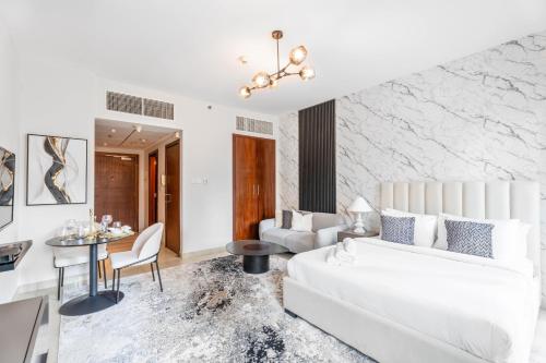 - un salon avec un canapé blanc et une table dans l'établissement Nasma Luxury Stays - Sophisticated Studio Apartment near Burj Khalifa, à Dubaï