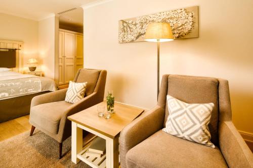 a hotel room with two chairs and a bed at Alter Meierhof Glücksburg in Glücksburg