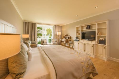 a living room with a large bed and a television at Alter Meierhof Glücksburg in Glücksburg