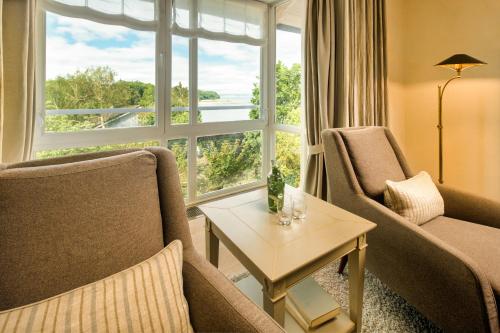 a living room with chairs and a table and a window at Alter Meierhof Glücksburg in Glücksburg