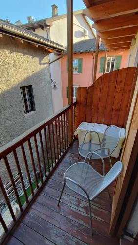um pátio com 2 cadeiras e uma mesa na varanda em BLA BLA in centro em Levico Terme