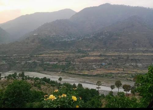 a view of a valley with a river and mountains at Hotel Bhajan Palace in Barkot