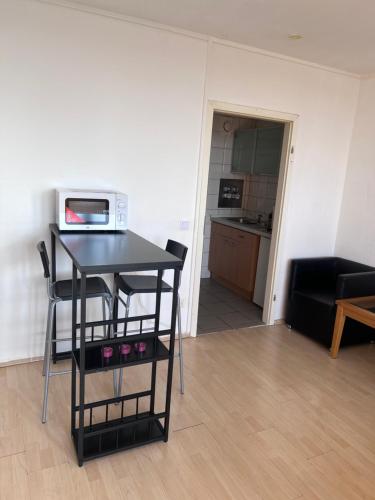 uma cozinha com uma mesa e um micro-ondas em Ferienwohnung in Köln 2910 em Colônia