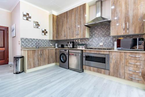 a large kitchen with wooden cabinets and appliances at RSA Lodge in Benoni