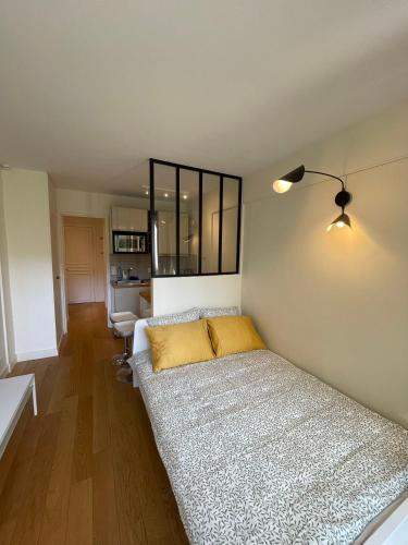 - une chambre avec un lit et un oreiller jaune dans l'établissement Dream Dwell Paris -Studio with Balcony 800m to Trocadéro and Tour Eiffel, à Paris