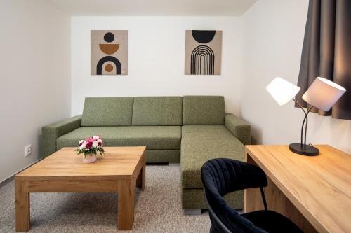 a living room with a couch and a coffee table at Hotel Granit Smrekovica in Liptovská Osada