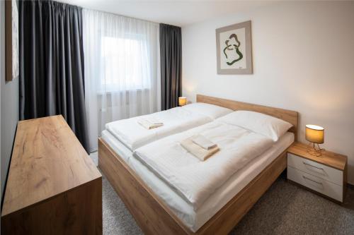 a bedroom with a large bed and a window at Hotel Granit Smrekovica in Liptovská Osada