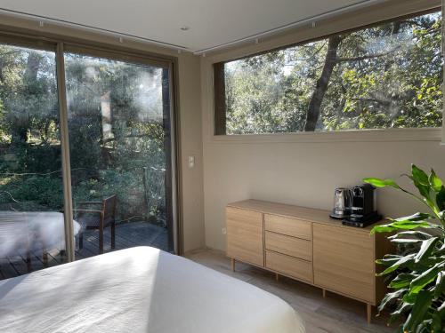 1 dormitorio con cama y ventana grande en La Canopée Private Lodge en Nimes