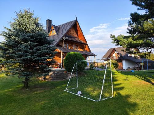 a house with a net in the grass in front of a house at Na Bugaju in Czarny Dunajec