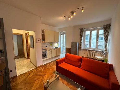 uma sala de estar com um sofá vermelho e uma cozinha em Casa Ciotti Appartamento in centro ad Aosta CIR 0124 em Aosta