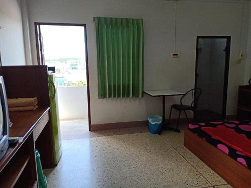 a room with a bed and a table and a window at RC Apartment in Krabi