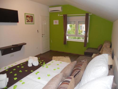 uma sala de estar com um sofá e uma parede verde em Apple Line Appartments em Mostar