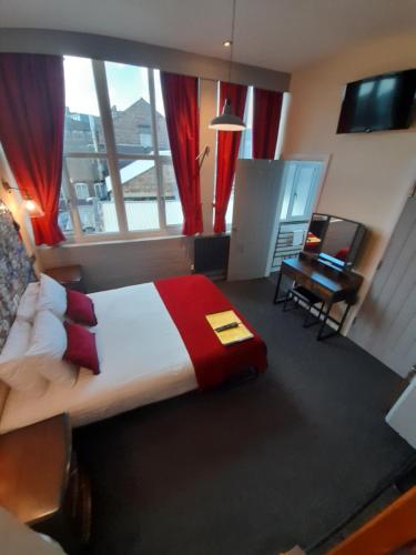 a bedroom with a bed and a desk and a window at Potbank in Stoke on Trent