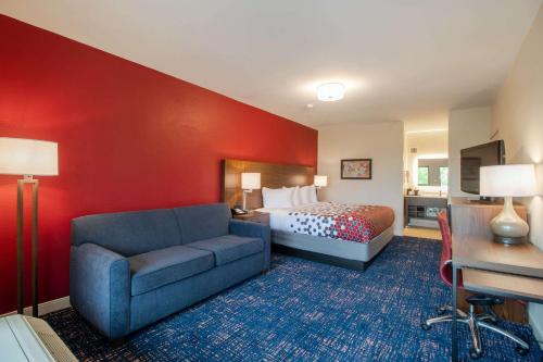 a hotel room with a bed and a couch at Econo Lodge Inn & Suites Foley-North Gulf Shores in Foley