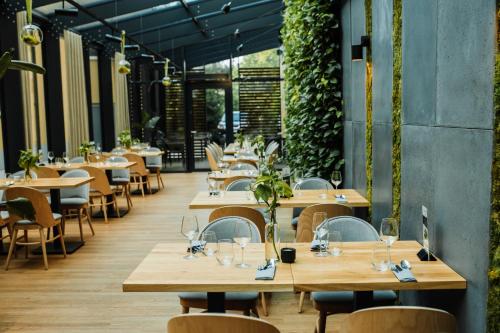 een leeg restaurant met houten tafels en stoelen bij Hotel Pod Jedlami in Wisła