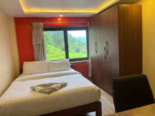 a bedroom with a large bed with a window at The North Face Inn's Homestay in Pokhara