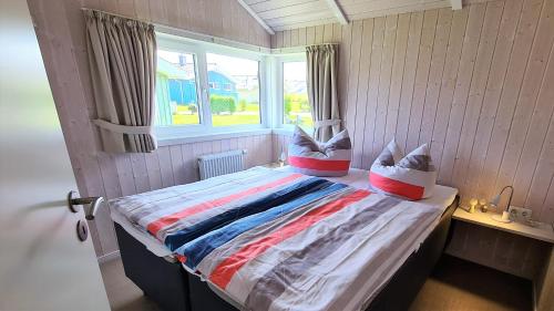 a small room with a bed with a window at Ferienhaus Strandoase in Brodersby