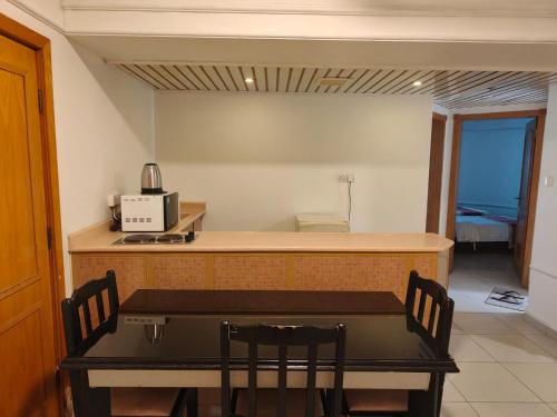 a kitchen with a table and a counter with chairs at منامي للشقق المخدومة-كورنيش الخبر-اقتصادي in Al Khobar