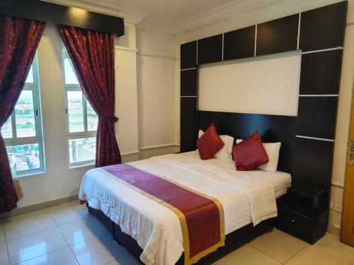 a bedroom with a large bed with red pillows at منامي للشقق المخدومة-كورنيش الخبر-اقتصادي in Al Khobar