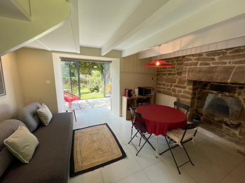 a living room with a table and a fireplace at Ker Bara in La Trinité-sur-Mer