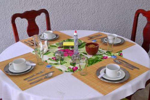 a table with a white table cloth with a table set with silverware at Pousada Vó Irene in Itacuruçá