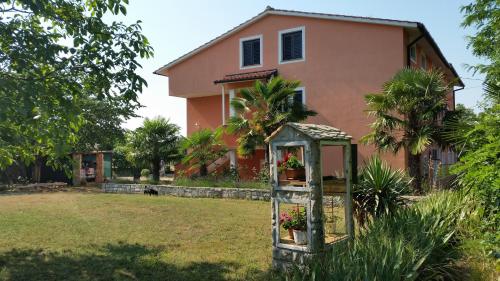a house with a garden in front of a house at Apartments Davor in Umag