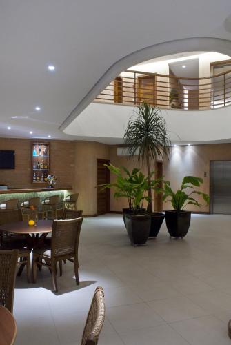 a lobby with a table and chairs and plants at Abayomi Hotel in Ilhabela