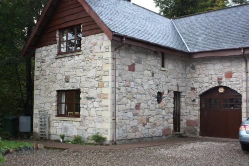 a stone building with a large door and a garage at Beechwood B+B in Fort William