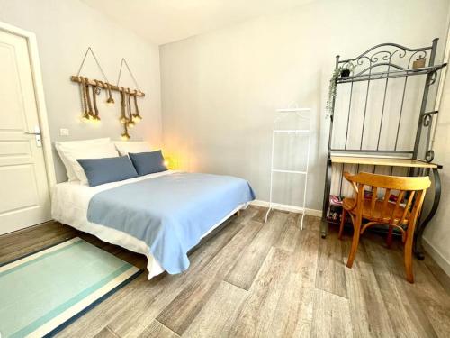une chambre avec un lit, un bureau et une chaise dans l'établissement L’azur - Centre ville & Lac, à Nantua
