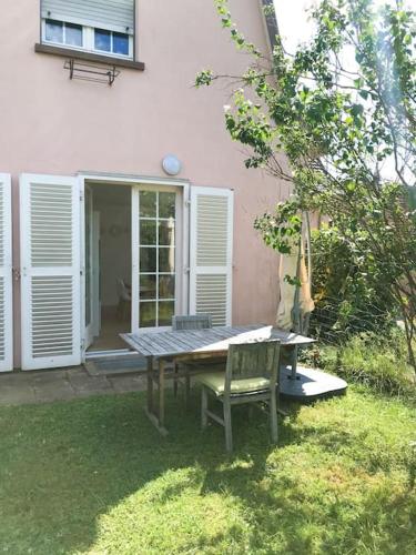 a table and a chair in front of a house at Gîte Niederbronn-les-Bains in Niederbronn-les-Bains