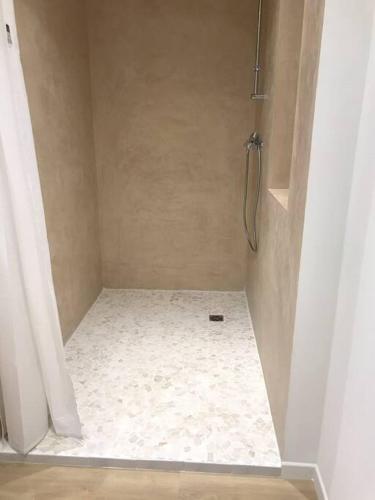 a bathroom with a shower with a white tile floor at Gîte Niederbronn-les-Bains in Niederbronn-les-Bains