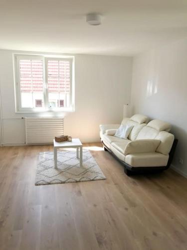 a living room with a white couch and a table at Gîte Niederbronn-les-Bains in Niederbronn-les-Bains
